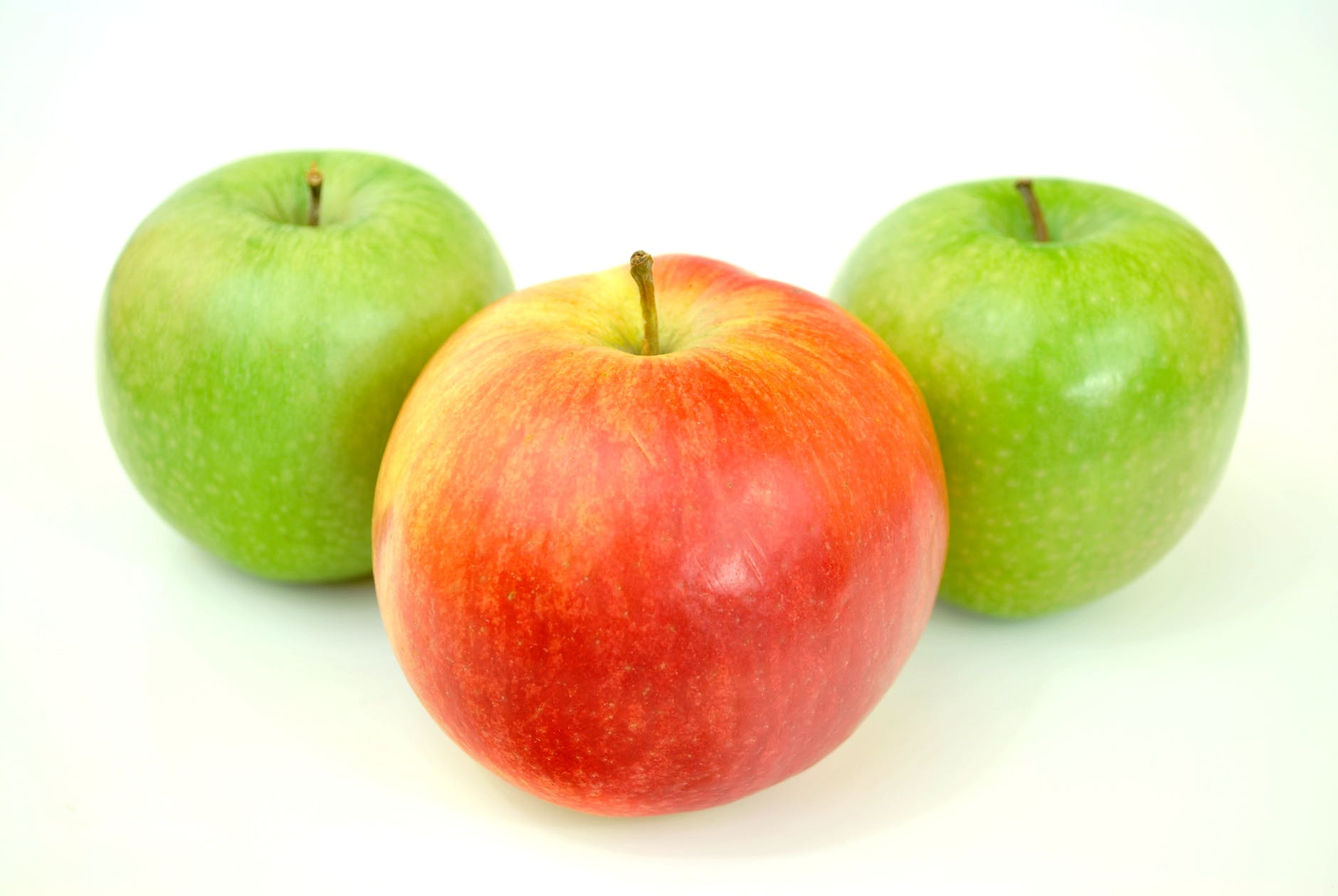 red apple with two green apples